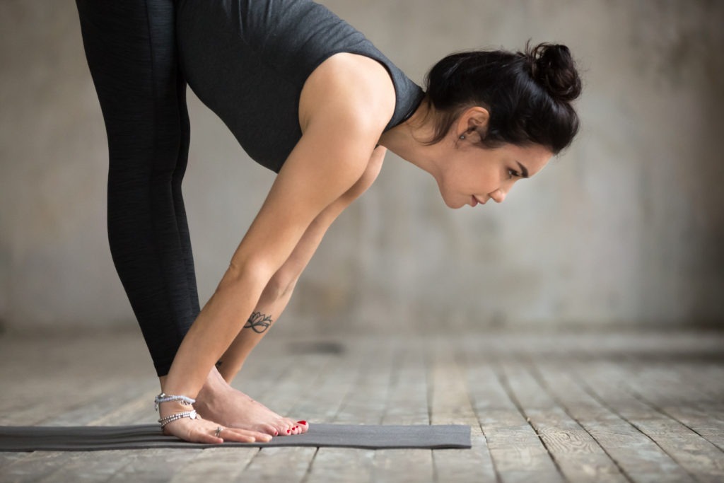 Woman doing Standing Forward Fold Pose, Intense Stretch Pose